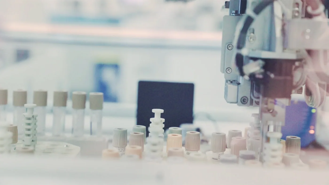 Laboratoire textile : machine de traction, crockmeter et échantillons numérotés en test.