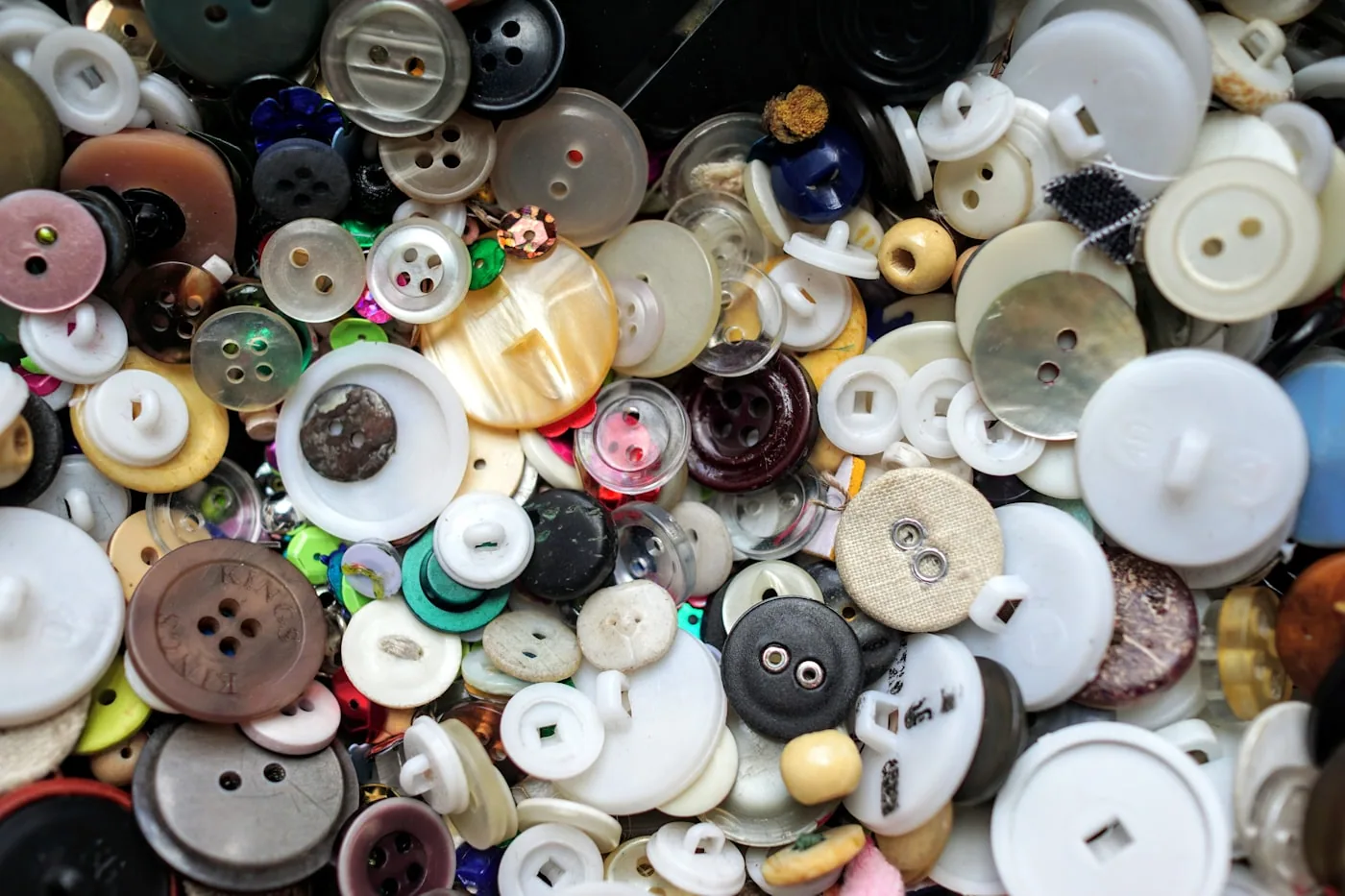 Sélection de zips spirale et métal, boutons corozo et polyester, pressions, présentés avec références.