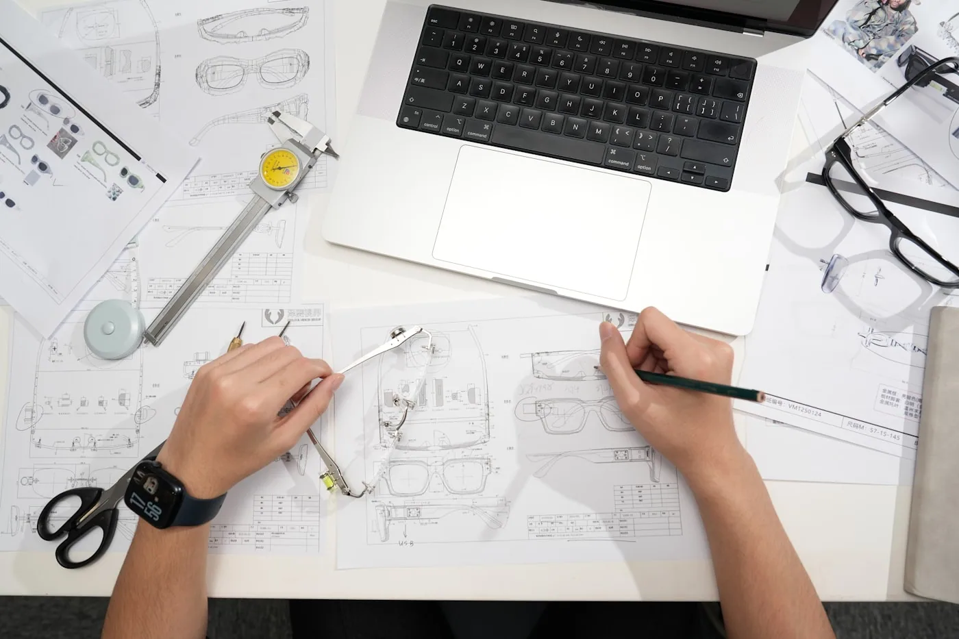 Dessins techniques à plat d’un T-shirt face et dos avec flèches de repérage des détails comme col, ourlets et surpiqûres.