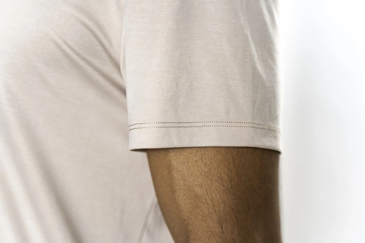 Gros plan d’un T-shirt en jersey coton montrant l’ourlet au coverstitch et la surpiqûre du col.