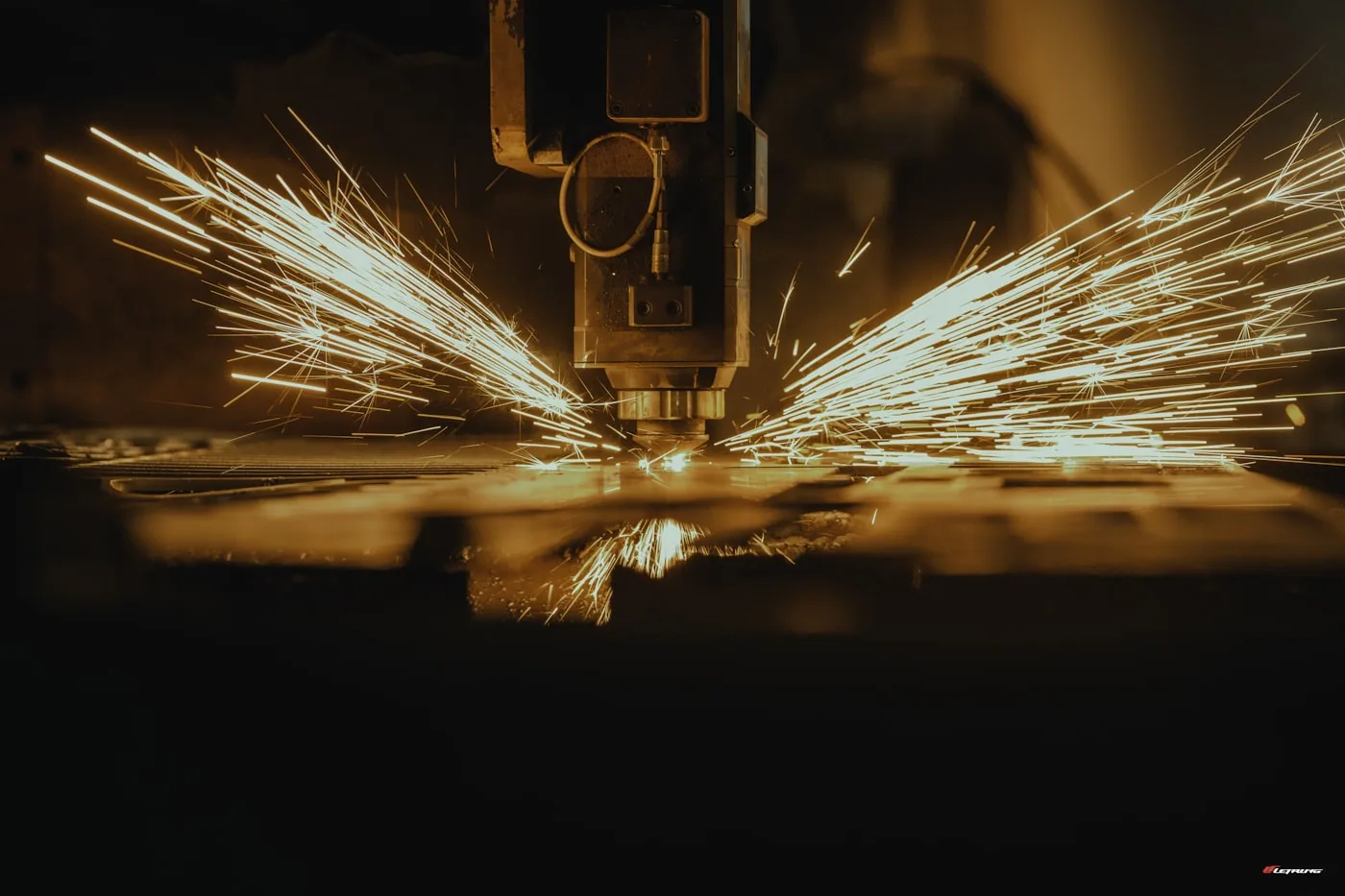 Table de coupe CNC avec auto-spreader alimentant une machine de découpe dans une usine d’habillement.