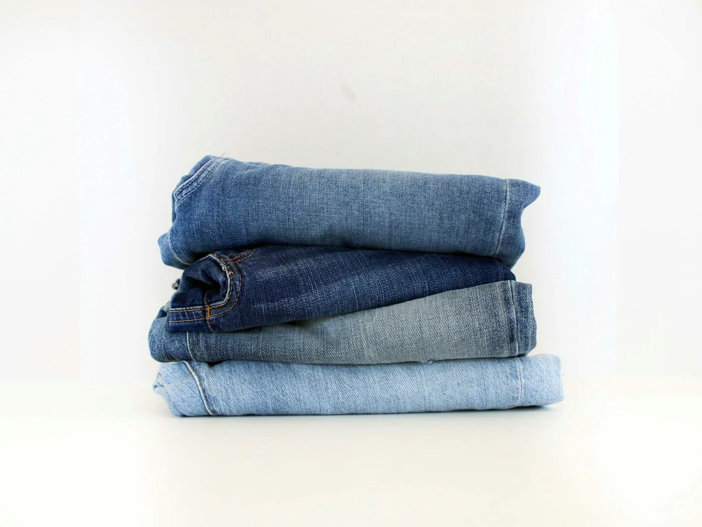Atelier de lavage denim avec machines industrielles, jeans pendus pour contrôle des teintes et effets.