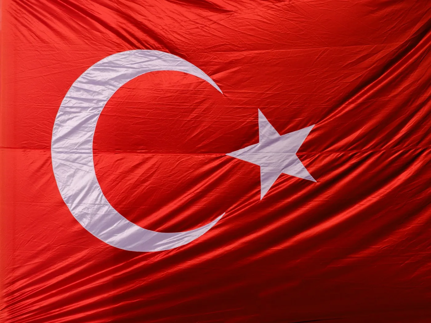 Atelier de confection en Turquie avec ouvriers à leurs postes et piles de jerseys et molletons.