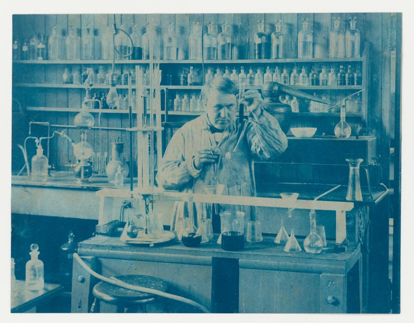 Plan de travail de laboratoire avec flacons de colorants étiquetés pour coton, polyester et nylon à côté d’échantillons de tissus.