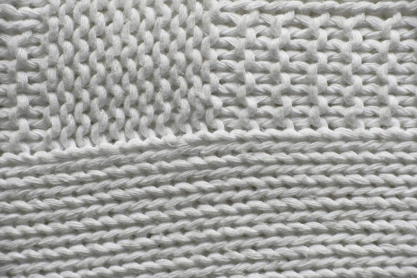Gros plan de différentes structures de maille : jersey lisse, côte, jacquard texturé.