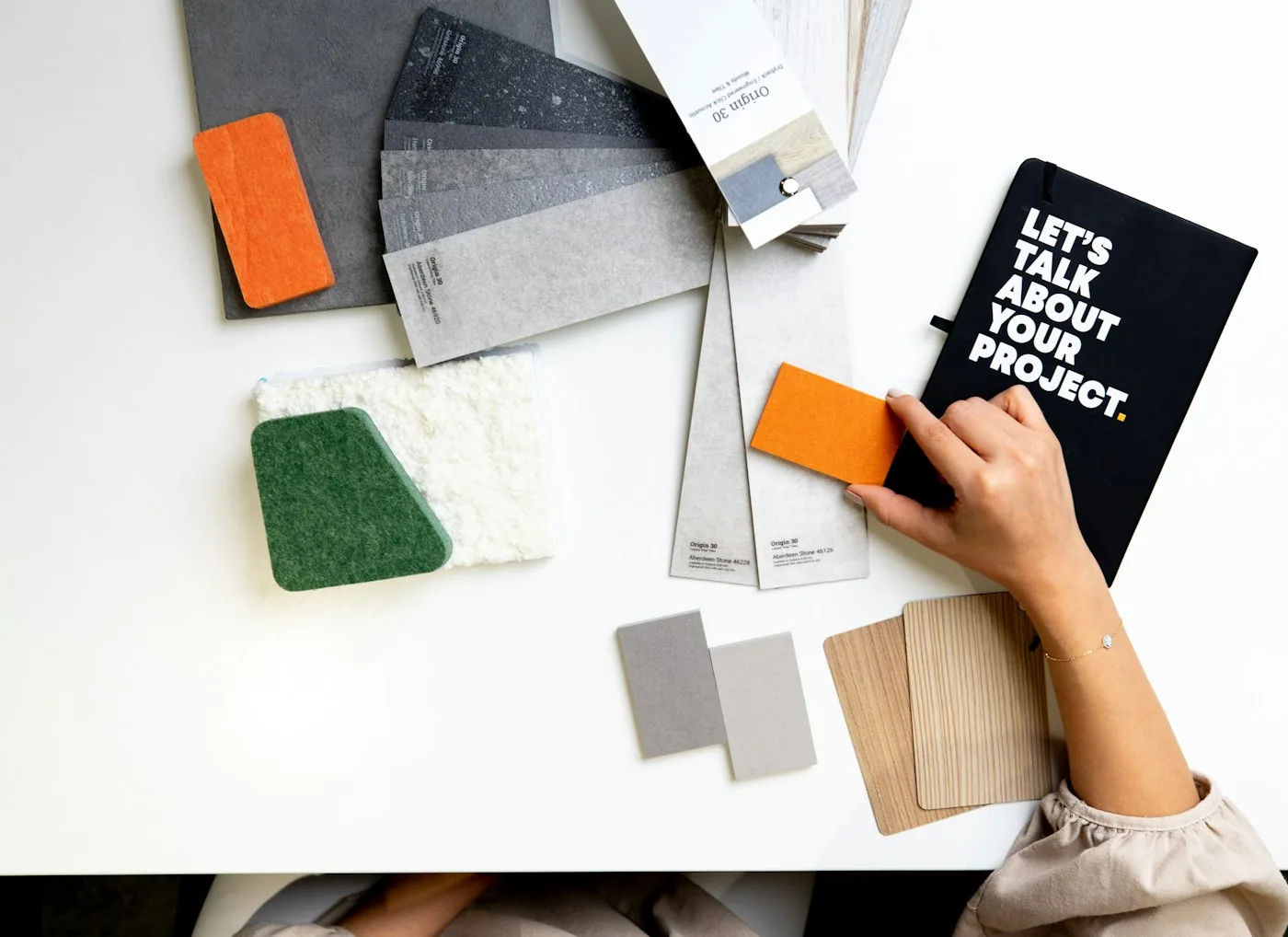 Un moodboard posé sur une table avec échantillons de tissus, nuancier de couleurs et notes de cible client.