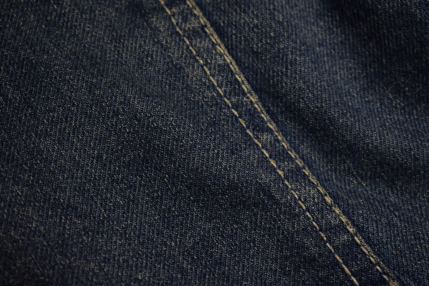 Gros plan sur une couture de veste montrant surpiqûres régulières et propreté intérieure.