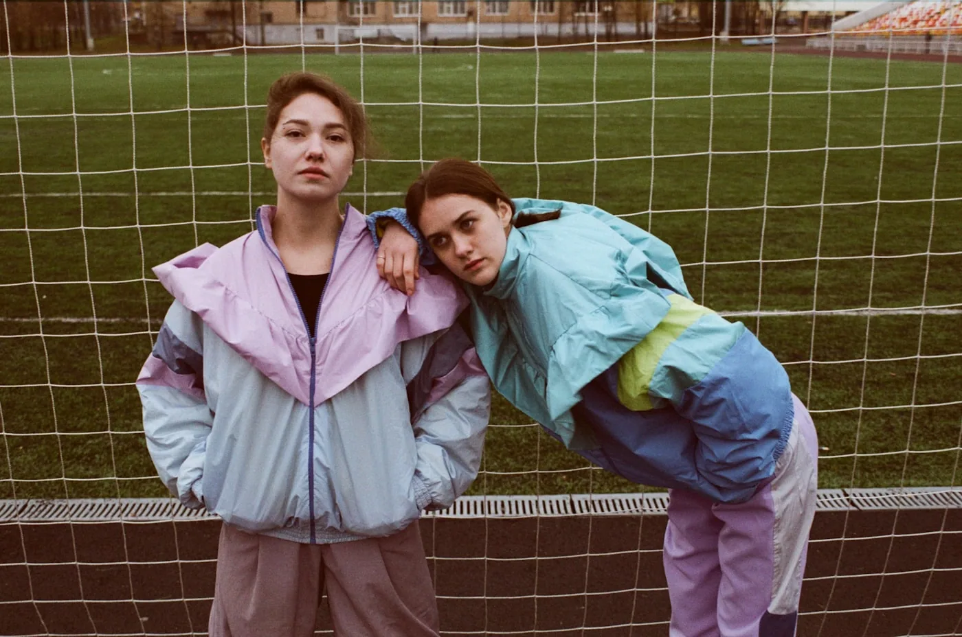 Vêtements de sport vintage archivés sur étagères, dont polaires et coupe-vents logotypés.