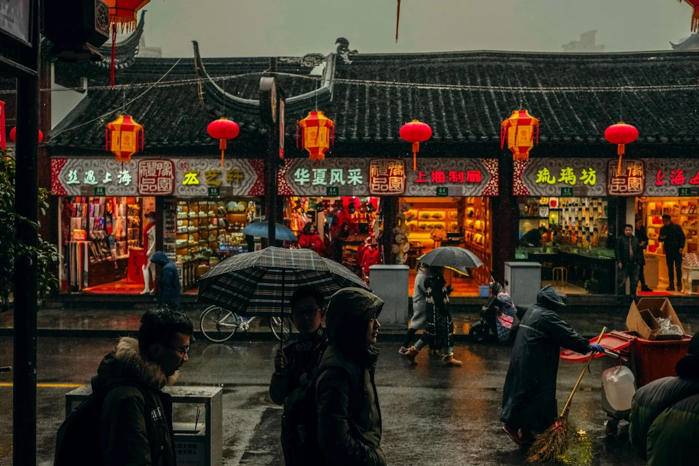 Allée d’un grand marché de tissus en Chine avec des rouleaux de tissus colorés empilés et des stands spécialisés.