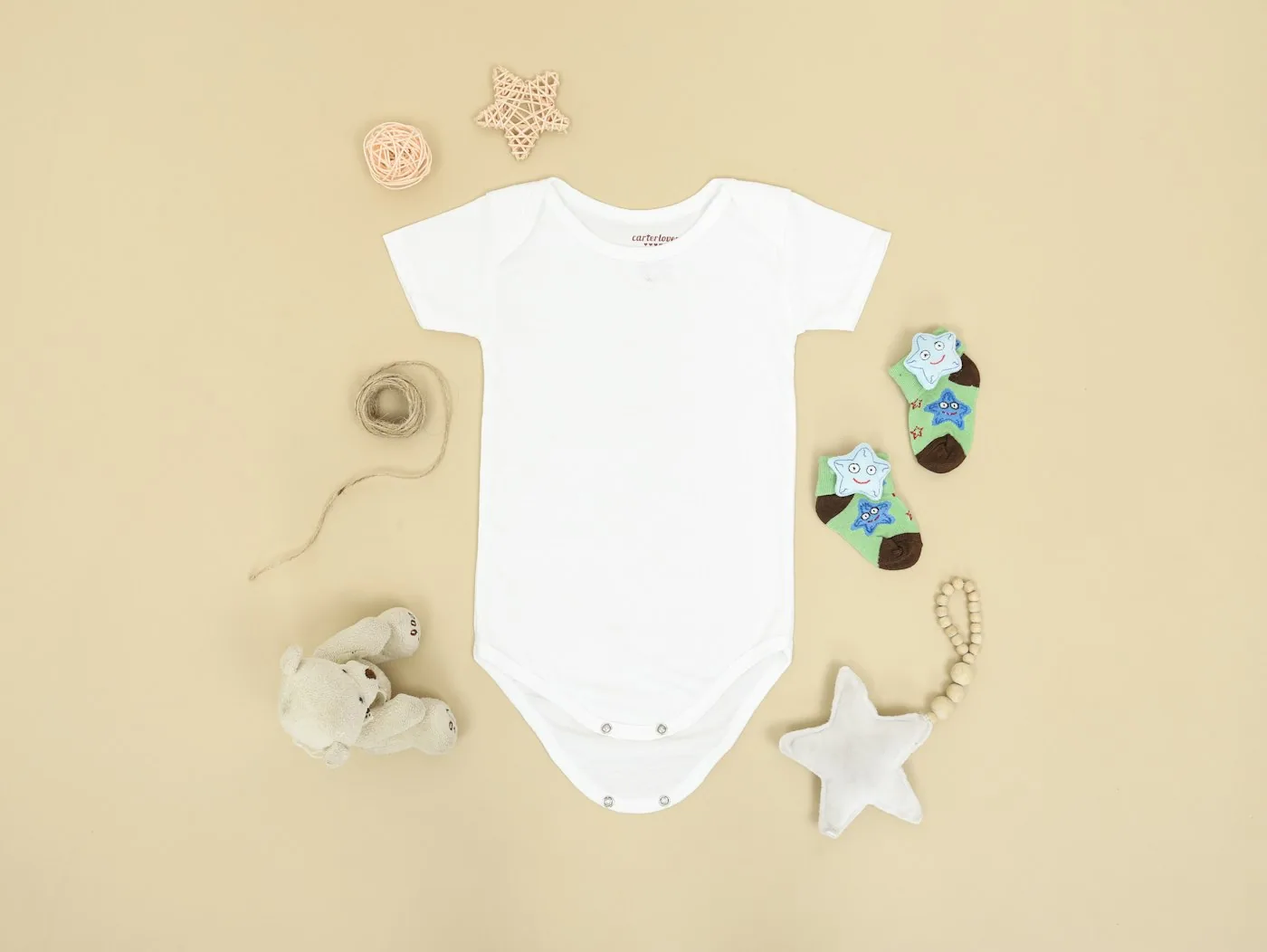 Portant avec plusieurs bodies bébé en coton de couleurs claires.