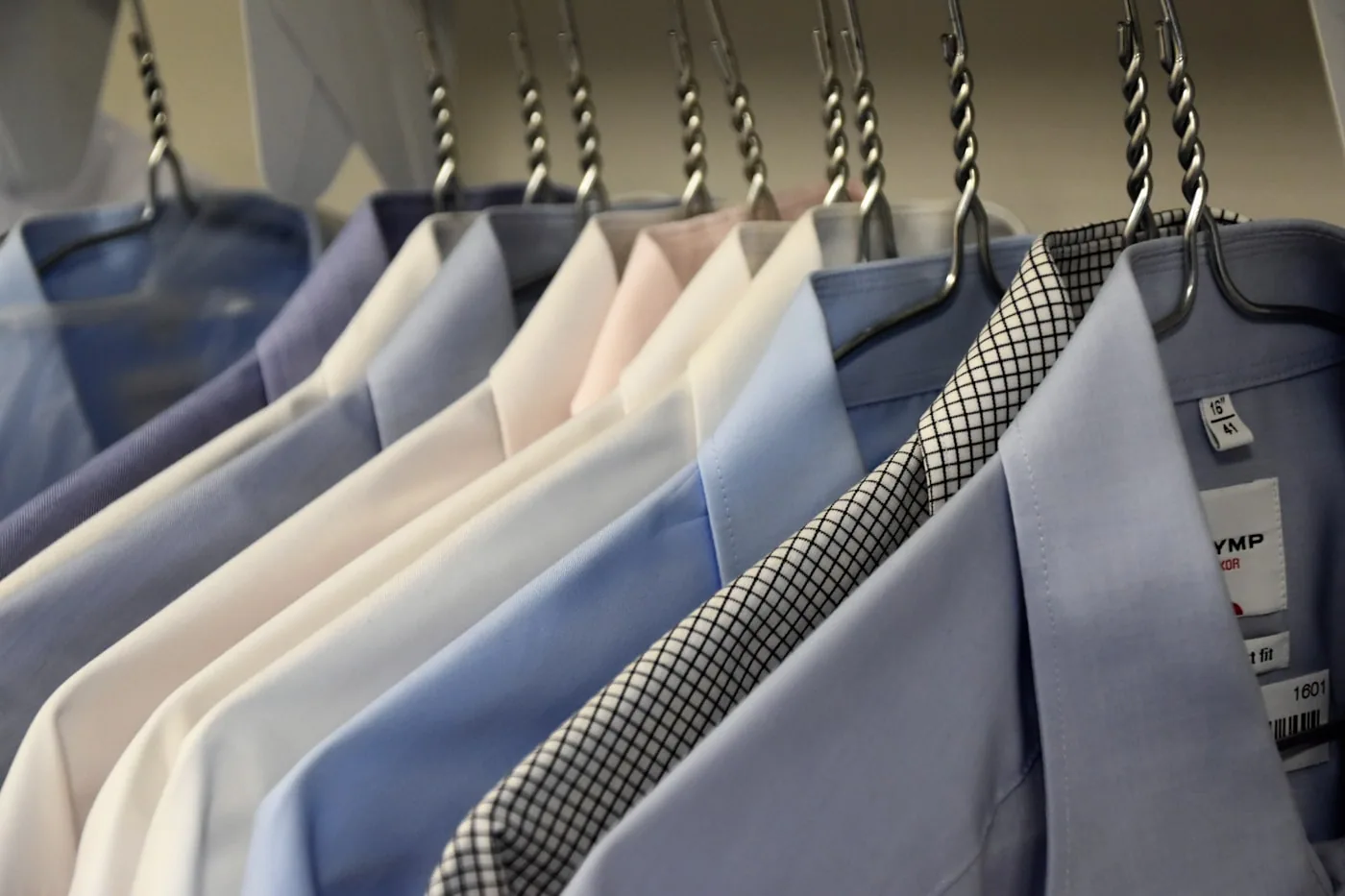 Portant de vêtements d’une même référence avec plusieurs tailles étiquetées S à XL.