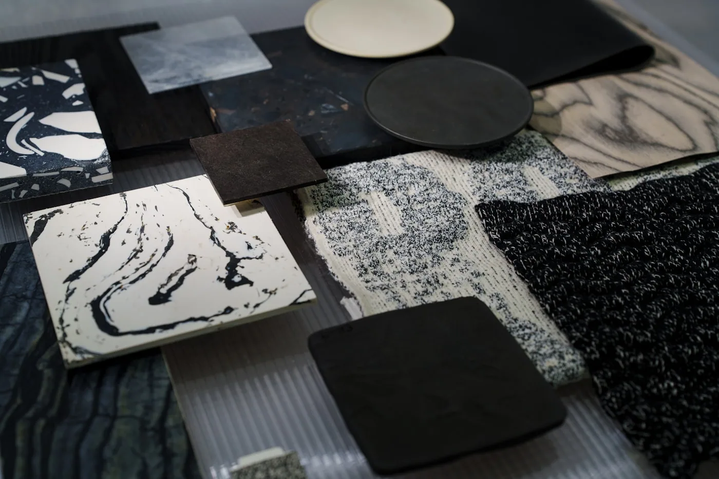 Table d’atelier avec plusieurs types d’échantillons: proto, fit sample avec ruban métrique, strike-off imprimé et PP sample étiqueté.