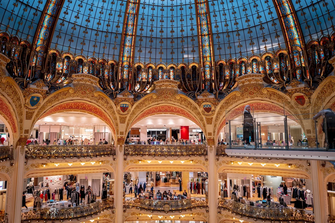 Hall d’exposition à Paris avec allées numérotées, stands de marques de mode et visiteurs professionnels.