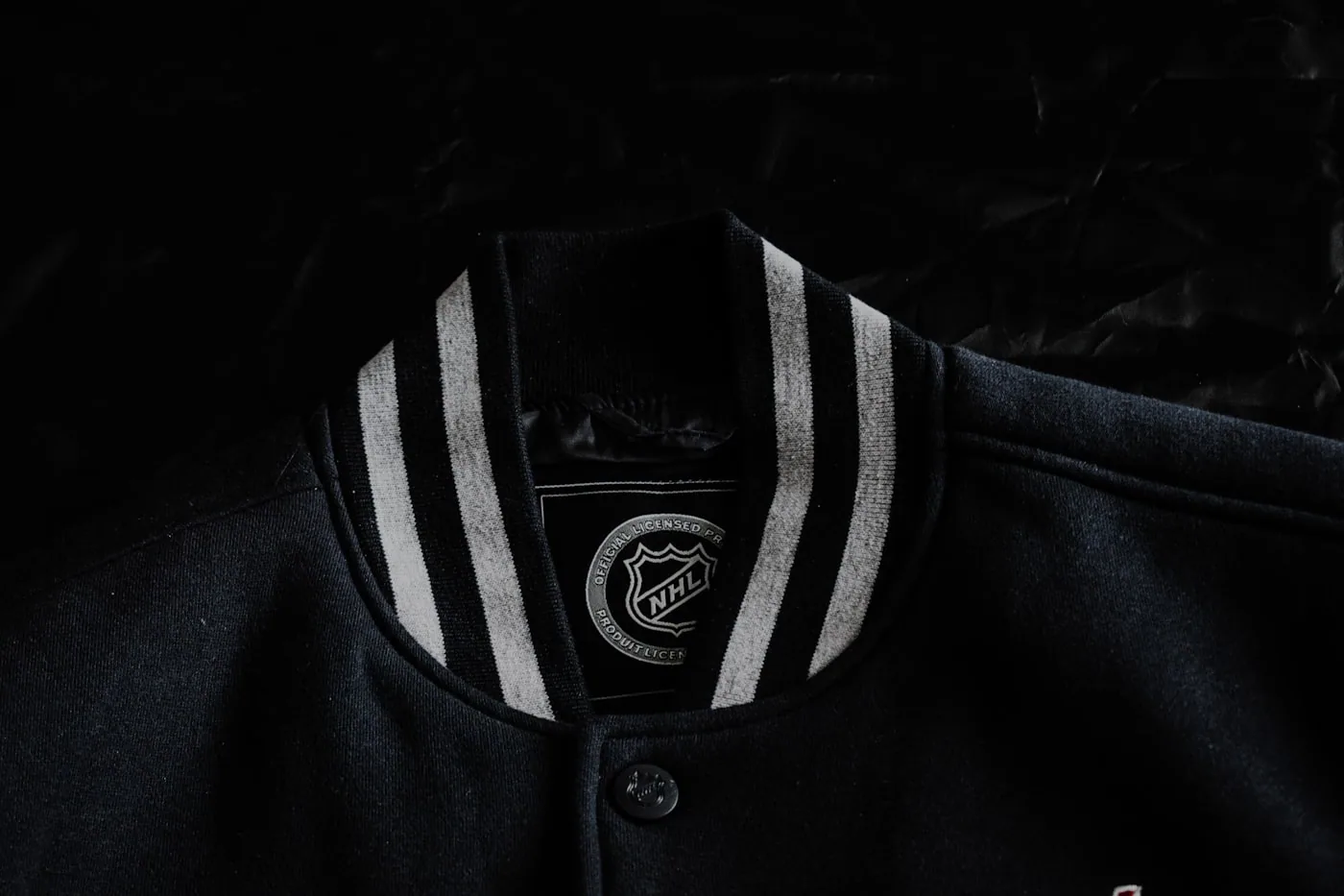 Veste varsity en laine avec lettres chenille sur un portant, bords-côtes denses.