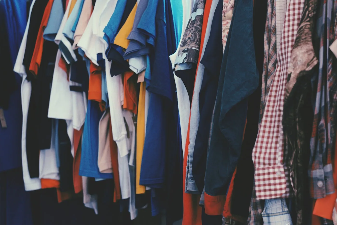 Étiquettes tissées de vêtements en gros plan, avec des noms de marque lisibles en très petit format.