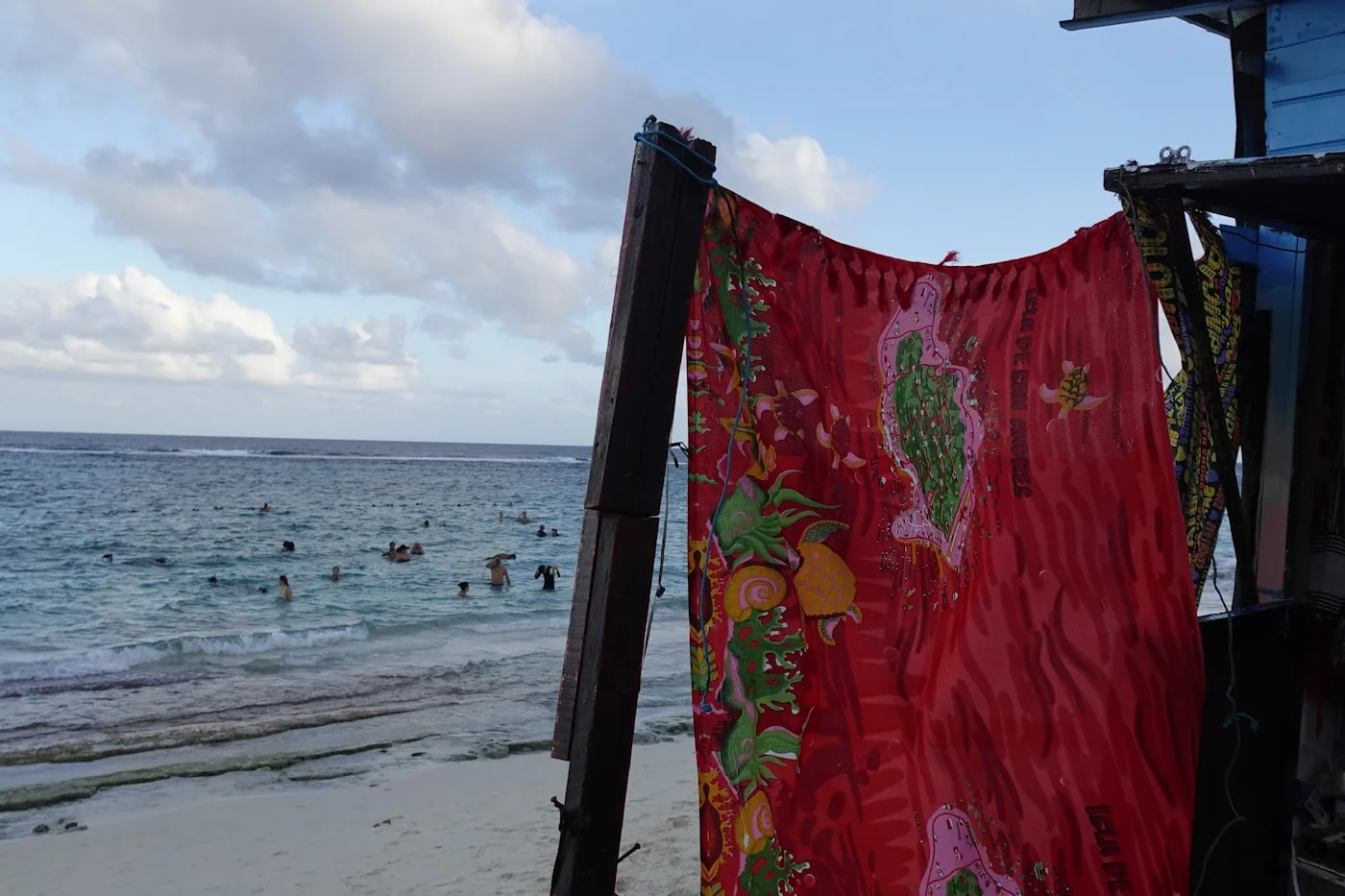 Paréos imprimés suspendus face à la mer